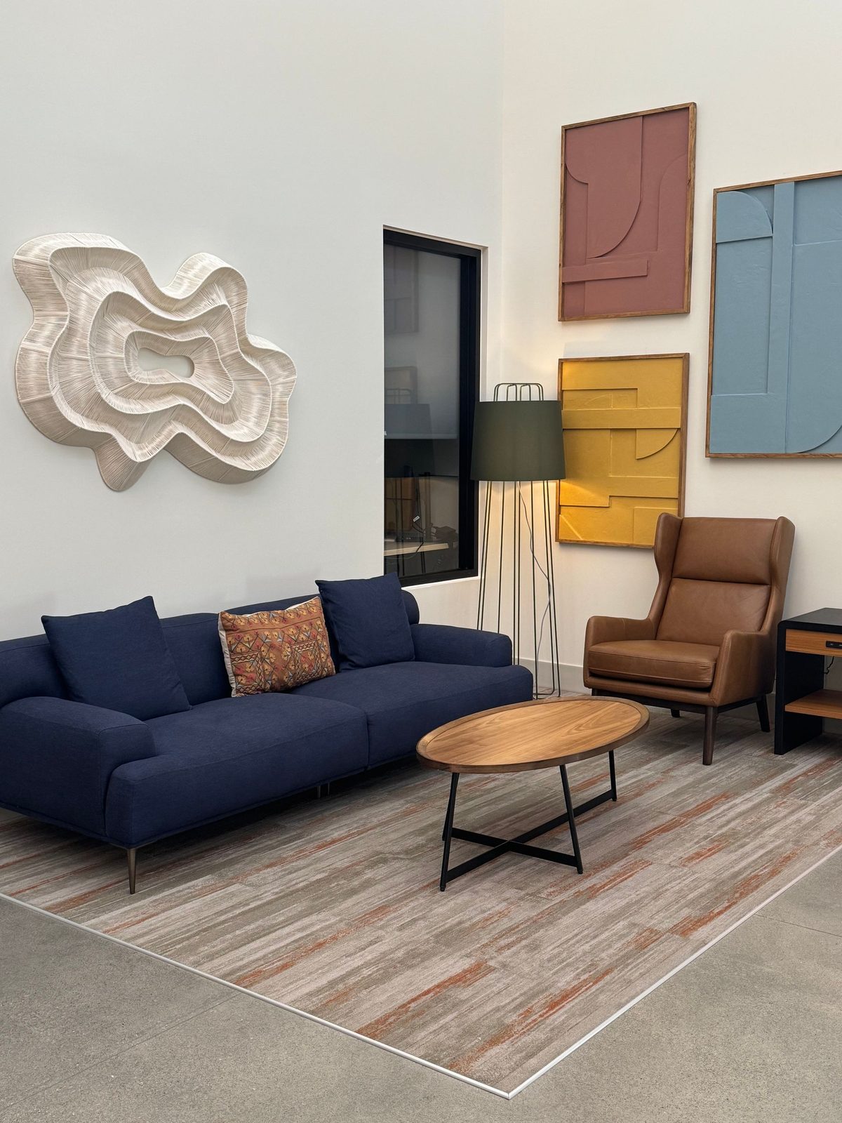 A calm, sunlit seating area with a blue sofa and warm wood